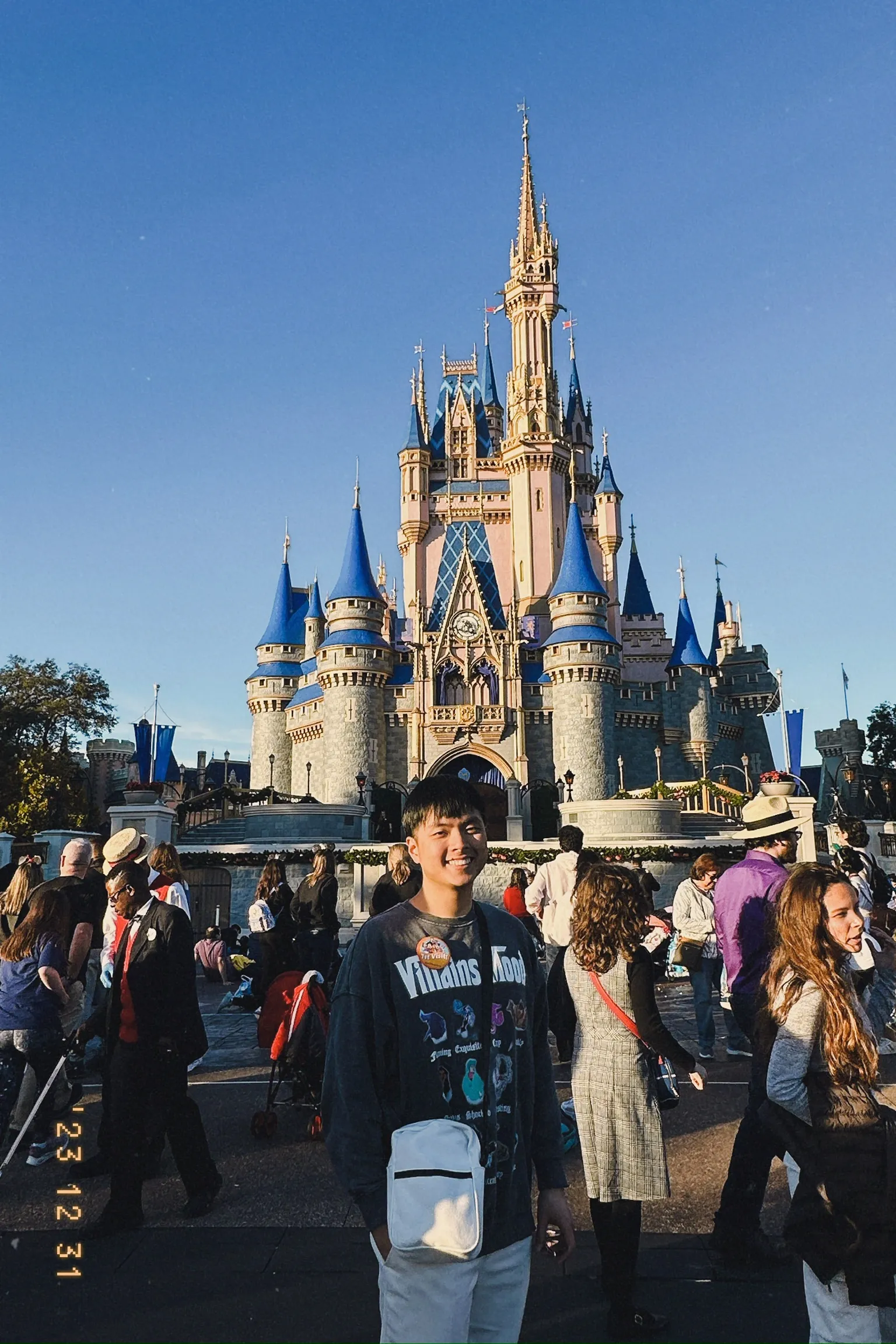 Daniel standing in front of Disney Land with smile.